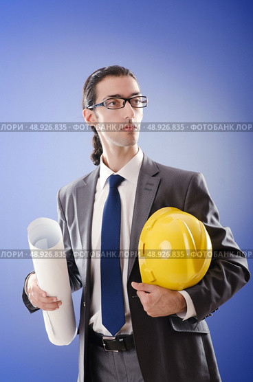 Young architect with drawings and hardhat. Стоковое фото, агентство Ingram Publishing / Фотобанк Лори