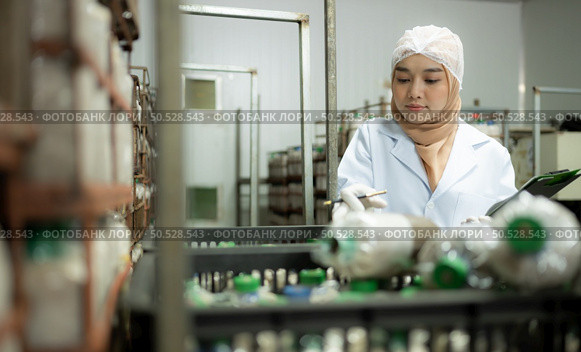Young asian muslim female scientist doing research at a mushroom factory, examining mushroom leavening agent in a sterile and temperature-controlled room. Стоковое фото, агентство Ingram Publishing / Фотобанк Лори