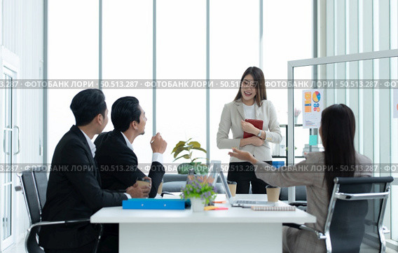 Young asian woman freshmen in the new generation of entrepreneurs team. Successfully presented the project to the satisfaction of the management. Стоковое фото, агентство Ingram Publishing / Фотобанк Лори