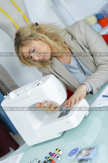 young attractive needlewoman at studio working with sewing machine. Стоковое фото, агентство Ingram Publishing / Фотобанк Лори