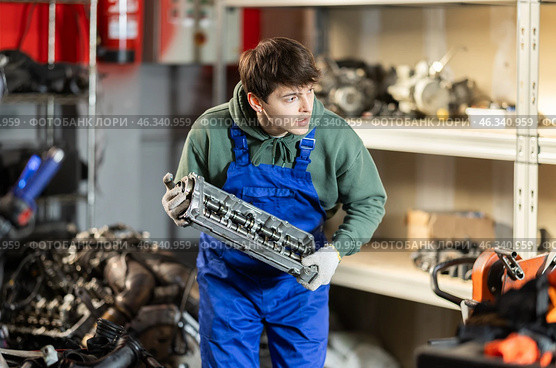 Young auto mechanic repairing an engine in garage. Стоковое фото, фотограф Яков Филимонов / Фотобанк Лори
