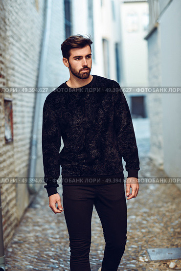 Young bearded man, model of fashion, walking in urban background wearing casual clothes. Guy with beard and modern hairstyle in the street. Стоковое фото, агентство Ingram Publishing / Фотобанк Лори