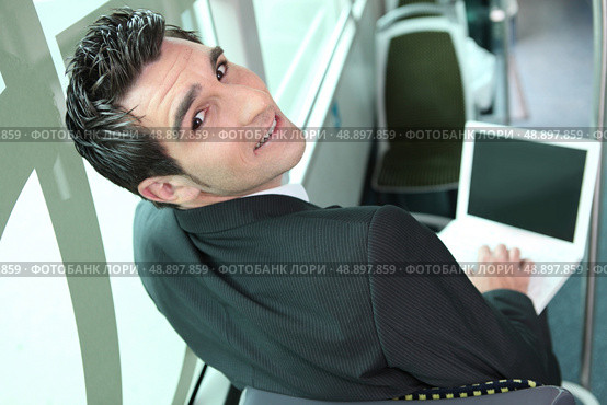 Young brown-haired man in a bus with computer. Стоковое фото, агентство Ingram Publishing / Фотобанк Лори