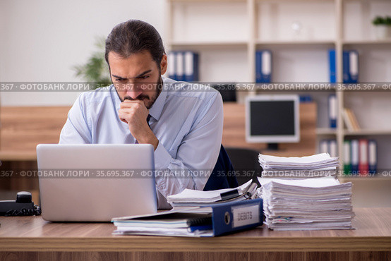 Young businessman employee unhappy with excessive work in the of. Стоковое фото, фотограф Elnur / Фотобанк Лори