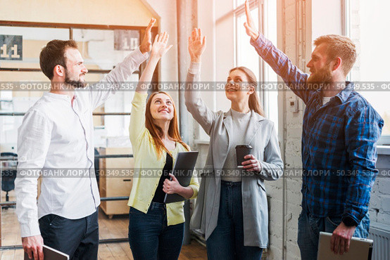 young colleagues giving high five each other. Стоковое фото, агентство Ingram Publishing / Фотобанк Лори