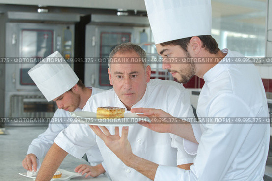 young confectioner presenting cake to chef. Стоковое фото, агентство Ingram Publishing / Фотобанк Лори