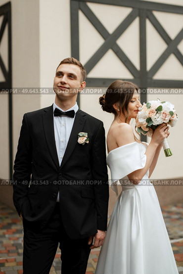 young couple bride and groom in a white short dress walking in the rain. Стоковое фото, агентство Ingram Publishing / Фотобанк Лори