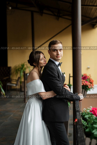 young couple bride and groom in a white short dress walking in the rain. Стоковое фото, агентство Ingram Publishing / Фотобанк Лори