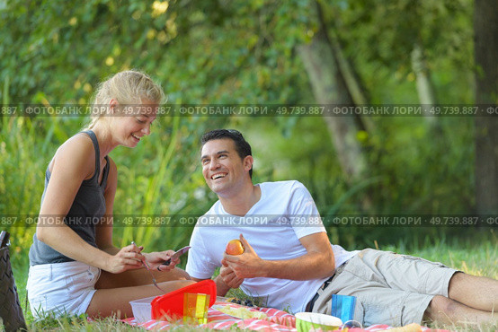 young couple lounging in sunny spring day at picnic outdoors. Стоковое фото, агентство Ingram Publishing / Фотобанк Лори