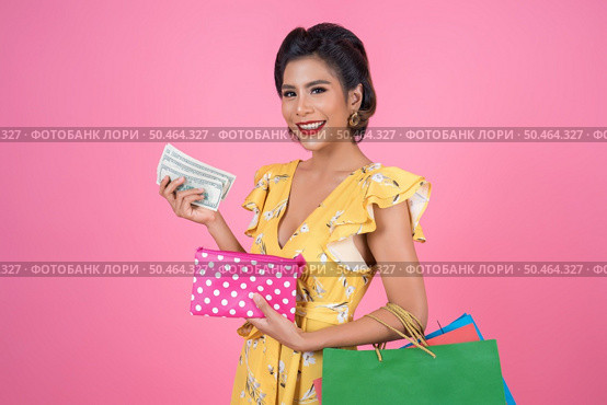 Young fashion woman hand holding wallet and shopping bags. Стоковое фото, агентство Ingram Publishing / Фотобанк Лори