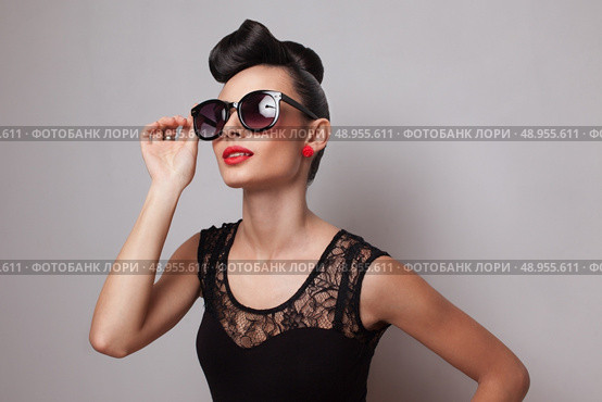 Young fashionable woman in round sunglasses posing in guipure dress. Red lips. Updo, twisted high bun. top knot. Стоковое фото, агентство Ingram Publishing / Фотобанк Лори