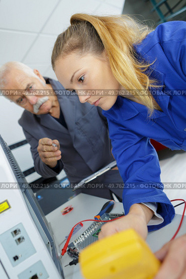 young female electrician with mentor. Стоковое фото, агентство Ingram Publishing / Фотобанк Лори