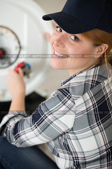 young female worker fixing a boiler. Стоковое фото, агентство Ingram Publishing / Фотобанк Лори