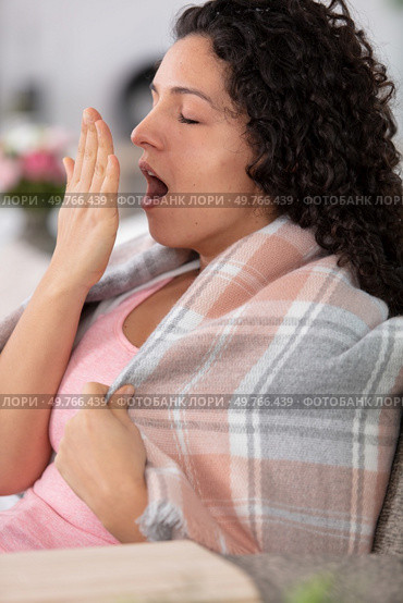 young girl sitting on the sofa and yawning. Стоковое фото, агентство Ingram Publishing / Фотобанк Лори