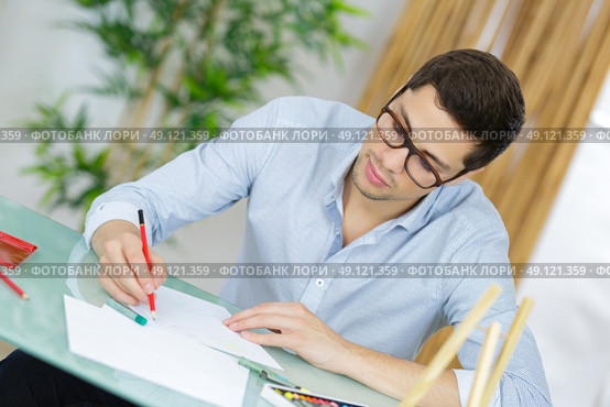 young handsome artist practise drawing as a hobby. Стоковое фото, агентство Ingram Publishing / Фотобанк Лори