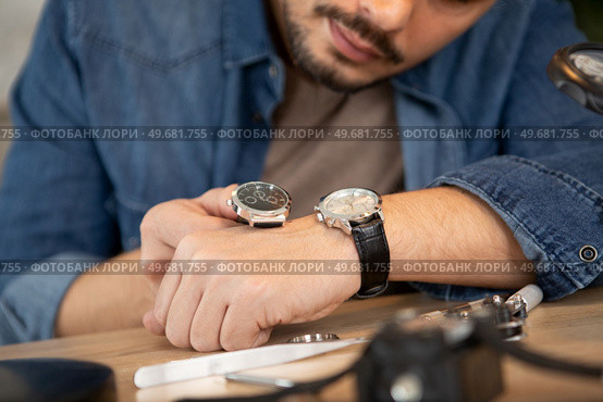 young handsome man checking the time on wrist watch. Стоковое фото, агентство Ingram Publishing / Фотобанк Лори