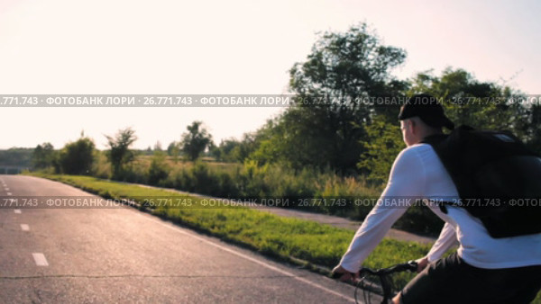 Young handsome man riding in the country road. Sporty guy cycling at the track. Стоковое видео, видеограф Алексндр Сидоренко / Фотобанк Лори