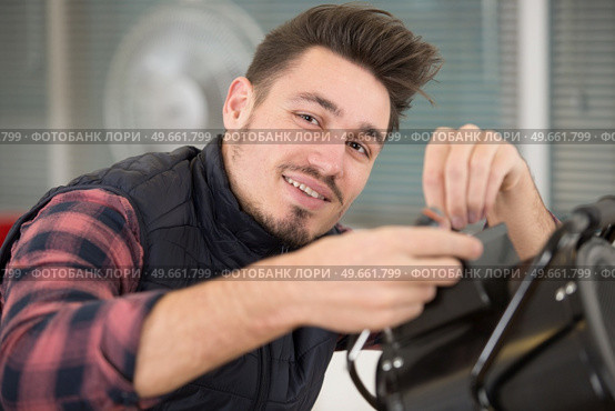 young handsome man working with a professional studio flash. Стоковое фото, агентство Ingram Publishing / Фотобанк Лори