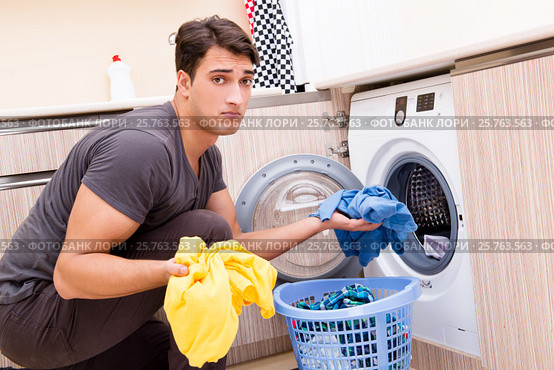 Young husband man doing laundry at home. Стоковое фото, фотограф Elnur / Фотобанк Лори
