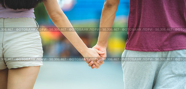 Young lovers couple hold hands, dating at amusement park, concept of happy, love, and relaxing. Стоковое фото, агентство Ingram Publishing / Фотобанк Лори