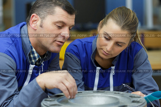 young male and female technicians in metalworks factory. Стоковое фото, агентство Ingram Publishing / Фотобанк Лори