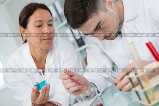 young male chemist smiling while hold test pipette in lab. Стоковое фото, агентство Ingram Publishing / Фотобанк Лори