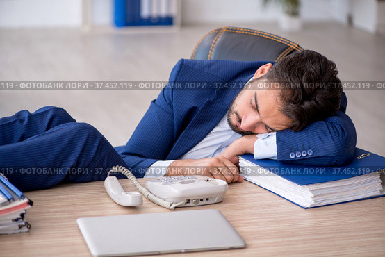 Young male employee extremely tired in the office. Стоковое фото, фотограф Elnur / Фотобанк Лори
