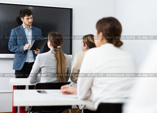 Young male tutor teaching students in college classroom. Стоковое фото, фотограф Яков Филимонов / Фотобанк Лори