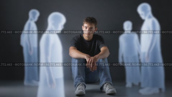 Young man feeling excluded, sitting alone with ghostly figures. Стоковое AI-видео, аниматор Юрий Поздников / Фотобанк Лори