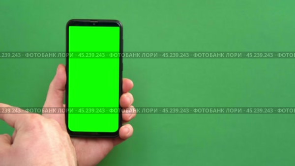 Young man hand use smartphone with green screen on green background. Gestures pack. Male hand touching, clicking, tapping swiping on black phone chromakey display. Close up Device. Modern Technology. Стоковое видео, видеограф Марина Демидюк / Фотобанк Лори