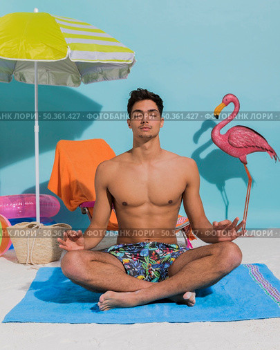 young man meditating decorative beach. Стоковое фото, агентство Ingram Publishing / Фотобанк Лори