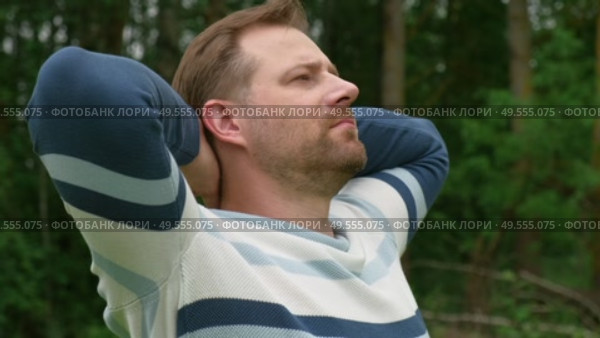 Young man stands with her arms outstretched to the side in the green park. Feeling free outdoor. Winning life achievement, freedom goal concept. Guy business employer, manager inspired in nature. Стоковое видео, видеограф Марина Демидюк / Фотобанк Лори