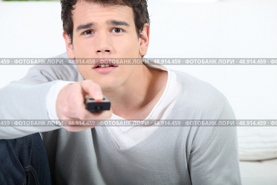 young man using a remote controller. Стоковое фото, агентство Ingram Publishing / Фотобанк Лори