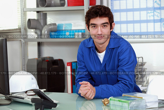 young man wearing a blue jumpsuite at office. Стоковое фото, агентство Ingram Publishing / Фотобанк Лори
