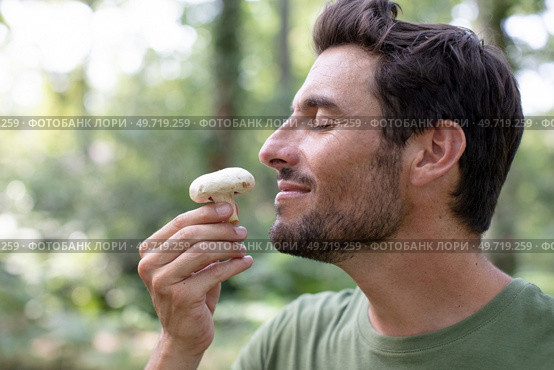 young man with a beard smelling mushroom. Стоковое фото, агентство Ingram Publishing / Фотобанк Лори