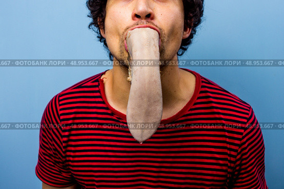 Young man with an ox tongue in his mouth. Стоковое фото, агентство Ingram Publishing / Фотобанк Лори