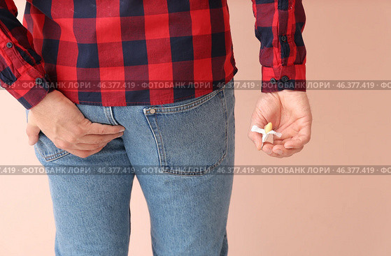Young man with hemorrhoidal suppository on color background. Стоковое фото, фотограф Pixel_shot / Фотобанк Лори