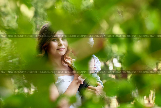 Young mother holds little boy while walks in park. Стоковое фото, фотограф Владимир Григорьев / Фотобанк Лори