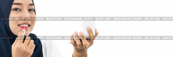 Young Muslim woman hold cosmetic and looking to camera to review product as vlog and blogger on white background taken in studio. Using for Fashion and beauty concept. Стоковое фото, агентство Ingram Publishing / Фотобанк Лори