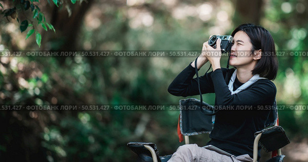 Young pretty woman use digital camera taking a photo beautiful nature while camping in forest with happiness, copy space. Стоковое фото, агентство Ingram Publishing / Фотобанк Лори