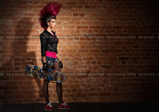 Young punk girl on brick wall background. Стоковое фото, агентство Ingram Publishing / Фотобанк Лори