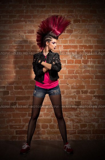 Young punk girl on brick wall background. Стоковое фото, агентство Ingram Publishing / Фотобанк Лори