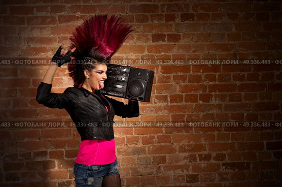 Young punk girl on brick wall background. Стоковое фото, агентство Ingram Publishing / Фотобанк Лори