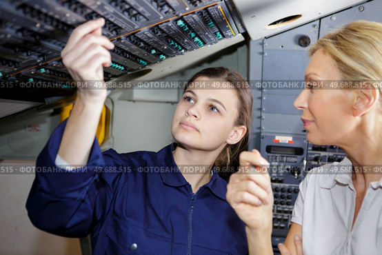 young woman airplane pilot checkin some digits. Стоковое фото, агентство Ingram Publishing / Фотобанк Лори
