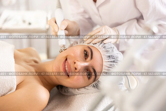 Young woman cosmetologist doing microcurrent procedure to young woman. Стоковое фото, фотограф Яков Филимонов / Фотобанк Лори