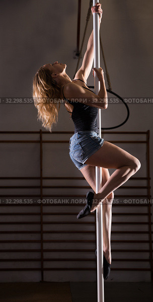 Young woman in denim shorts practicing pole dancing. Стоковое фото, фотограф Яков Филимонов / Фотобанк Лори