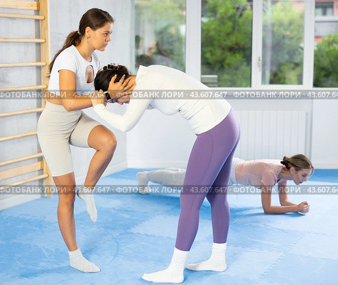Young woman in self-defense class practicing head hold with knee strikes to face. Стоковое фото, фотограф Яков Филимонов / Фотобанк Лори