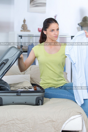 young woman is packing a suitcase. Стоковое фото, агентство Ingram Publishing / Фотобанк Лори