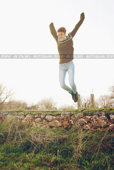 Young woman jumping outdoors . Стоковое фото, агентство Ingram Publishing / Фотобанк Лори