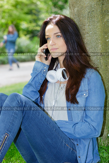 young woman phoning in the park. Стоковое фото, агентство Ingram Publishing / Фотобанк Лори